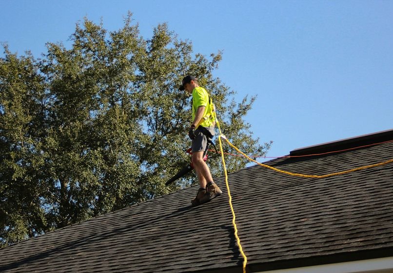 Roofer inspecting a shingle roof