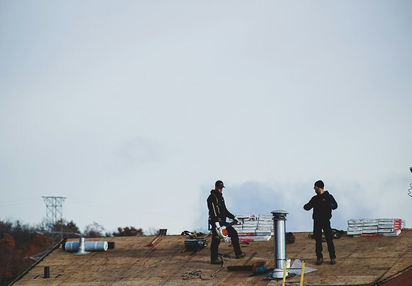 Roofers working on a damaged roof